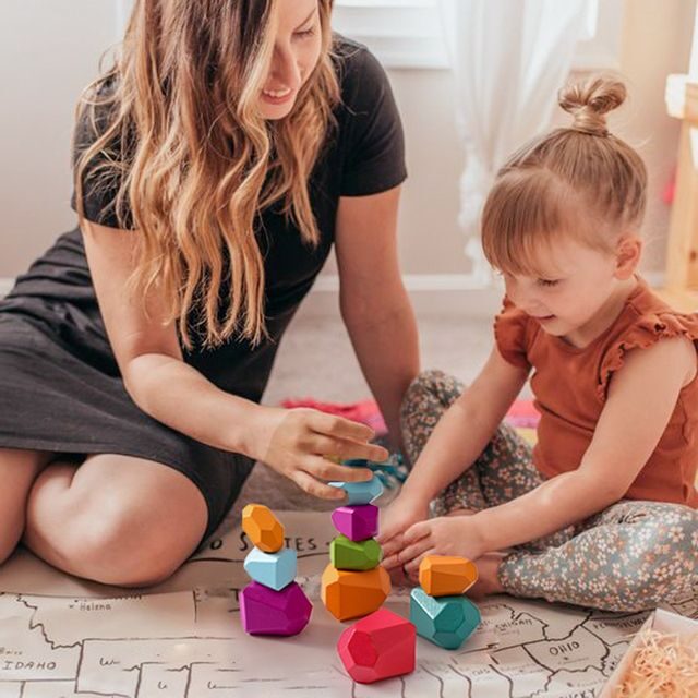 Mother playing with daughter using eco-friendly educational toys.